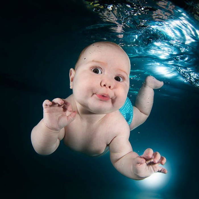 Baby boy swimming under water in a pool