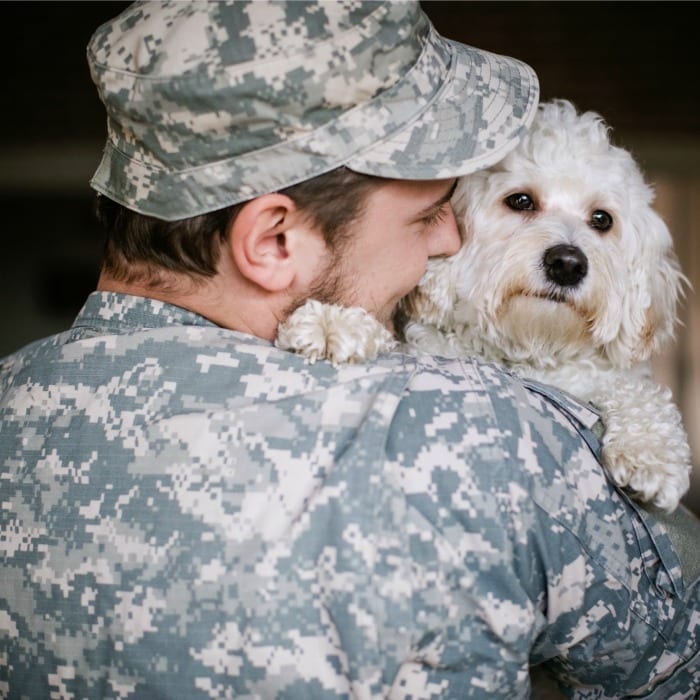 soldier cuddles pup