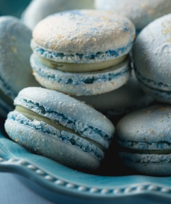 Closeup of blue cotton candy macarons with white chocolate ganache filling.