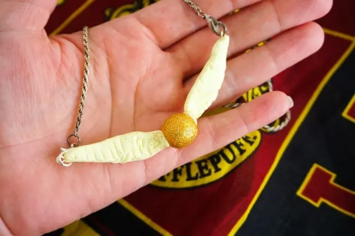 Seriously, I can't believe I caught it! Dude, this DIY Snitch Necklace is made to be Chased (and worn)! And it's so easy. #harrypotter #snitch #snitchnecklace #diyharrypotterjewelry #harrypotterjewelry #snitchjewelry