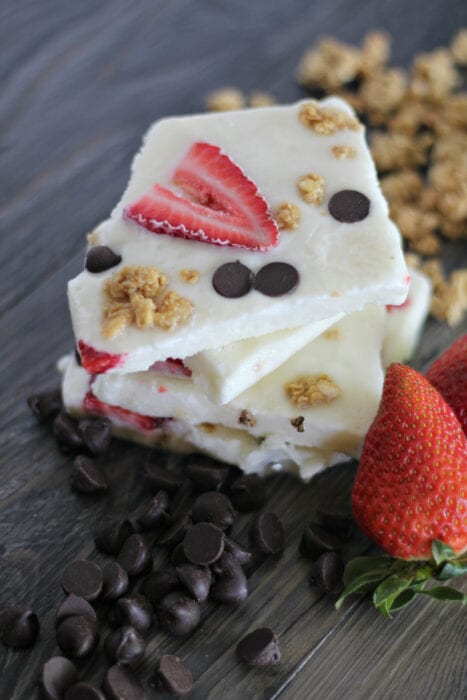 stacked frozen yogurt bark with chocolate chips and sliced strawberries