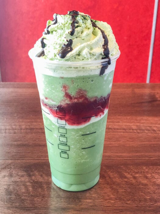 the strawberry drizzle in the middle of this macha frapp makes this Joker Frappuccino the perfect creepy drink 