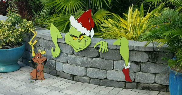 You Can Get A Christmas Decoration That Makes It Look Like The Grinch Is Hopping Over Your Fence