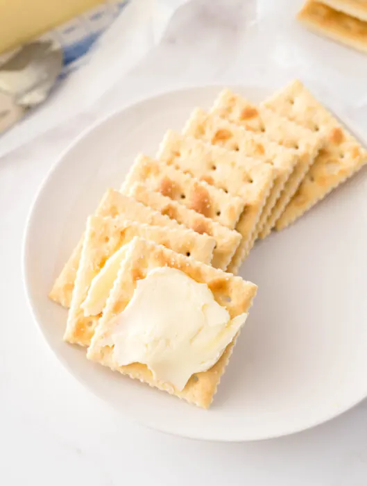 buttered saltine crackers on a plate