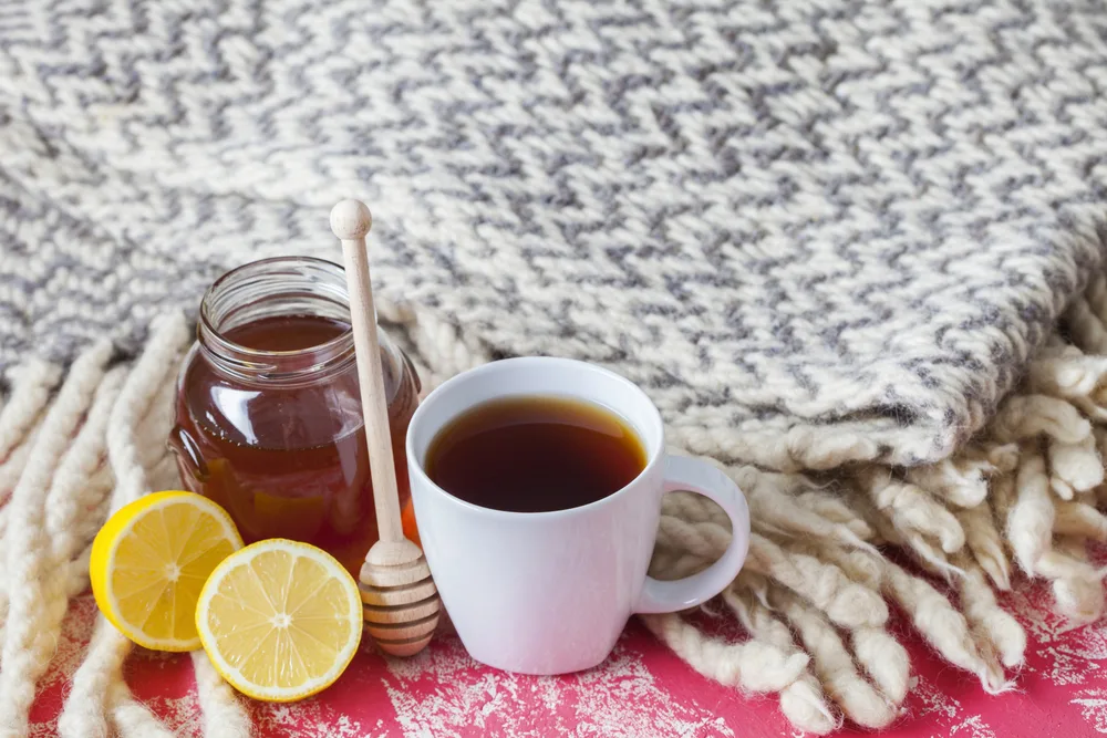 homemade starbucks medicine ball tea in a white mug with lemon and honey