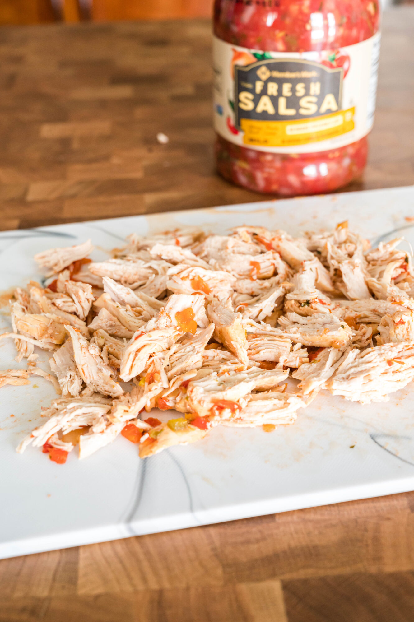 shredded chicken salsa on cutting board
