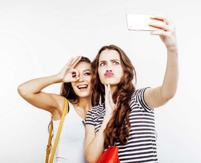 Women lesbians enjoy spare time in park, pose for making selfie in smart  phone. Pretty female kisses her best friend in cheek, expresses love, have  truthful relationships. Leisute time concept Stock Photo |